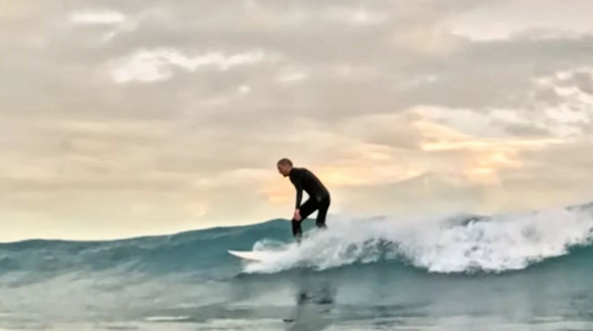 Trimming into golden evening light as the bay glasses off and the sun drops, Hickory Bay surf spot, Canterbury, New Zealand.