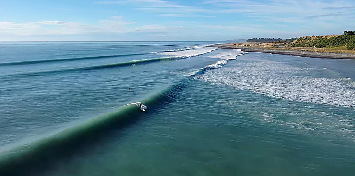 A long green wall reels down the point from above, the cobble beach tracing the bay, Mangamaunu surf spot, Kaikoura / North C