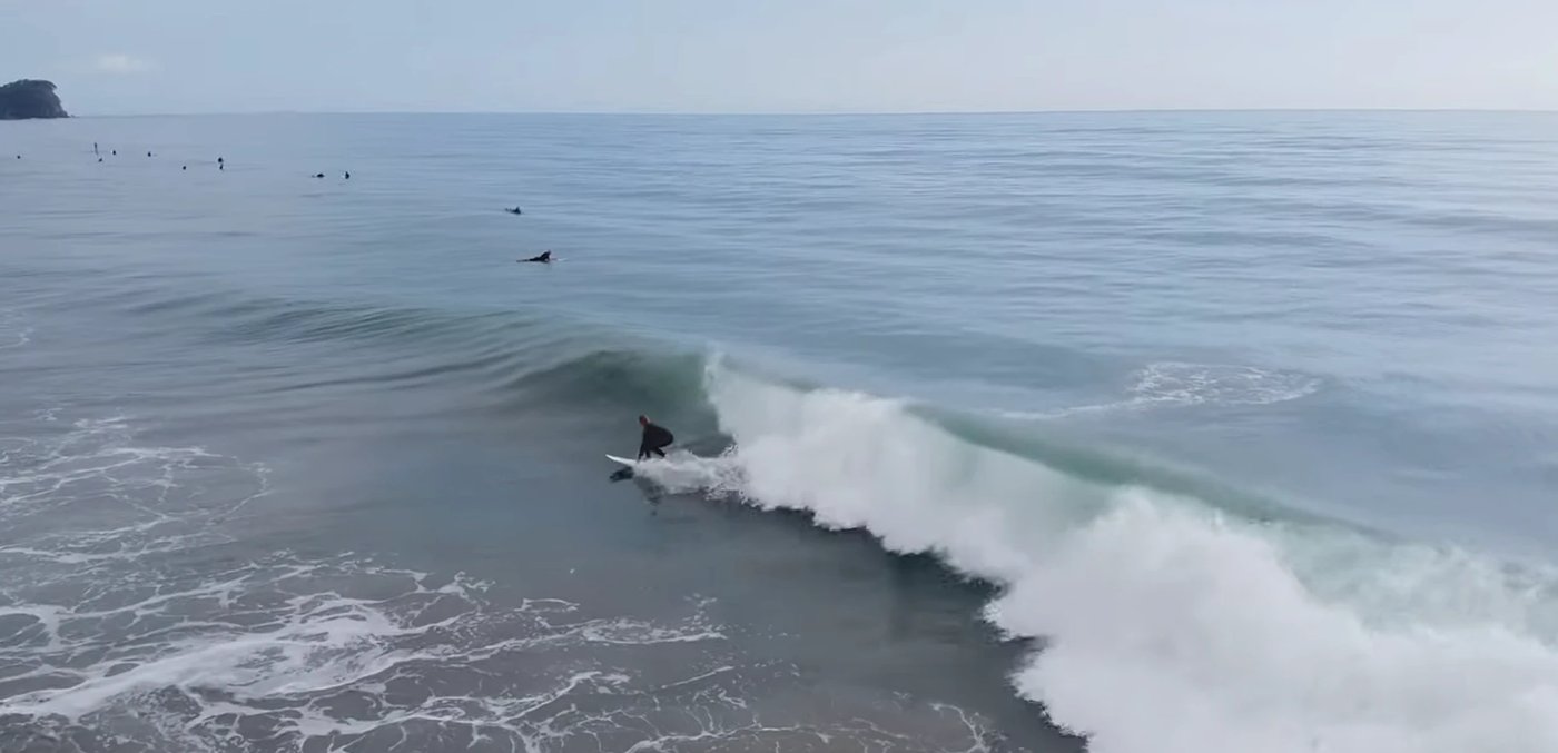 Drone close-up of a Tay Street wave with the Mount on the horizon, Mt Maunganui - Tay Street surf spot, Bay of Plenty, New Ze