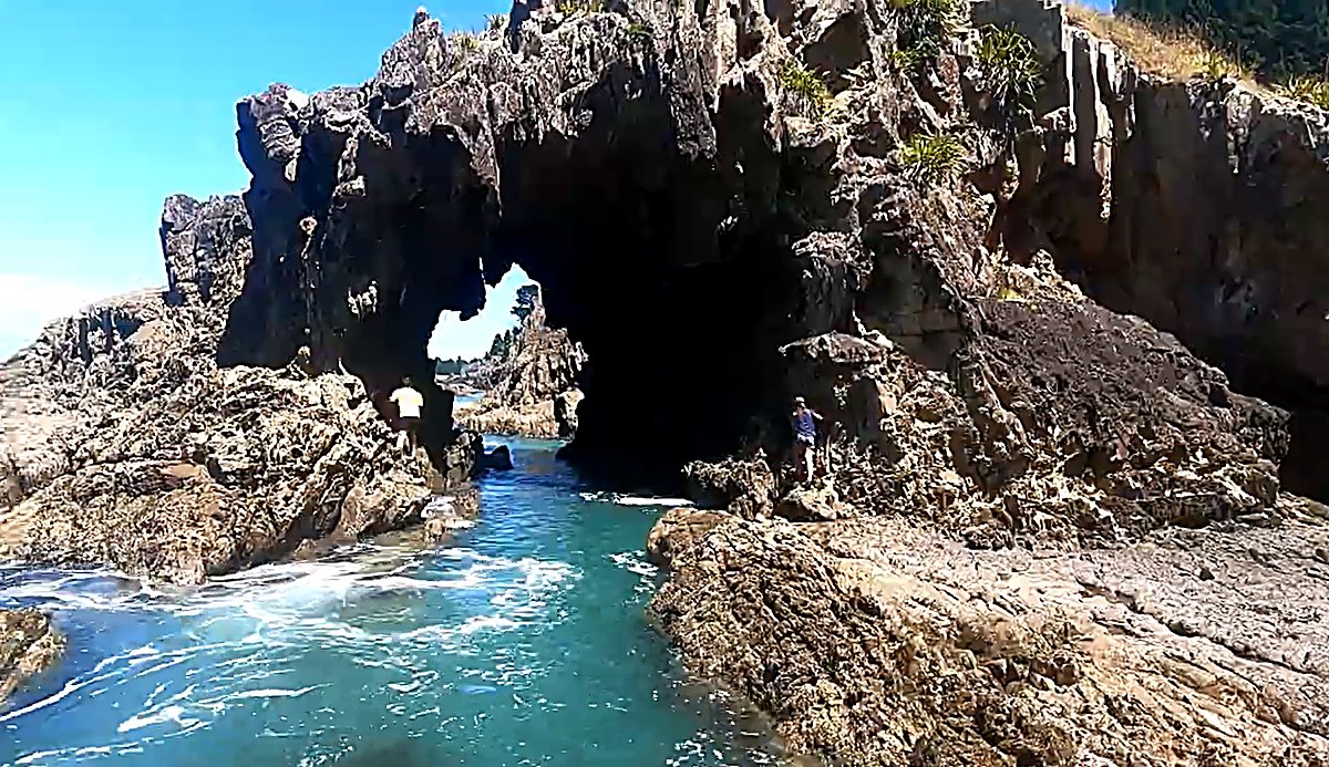 Clear water funnels through the sea arch, the kind of feature that rewards a poke around between waves, Robin Hood Bay surf s