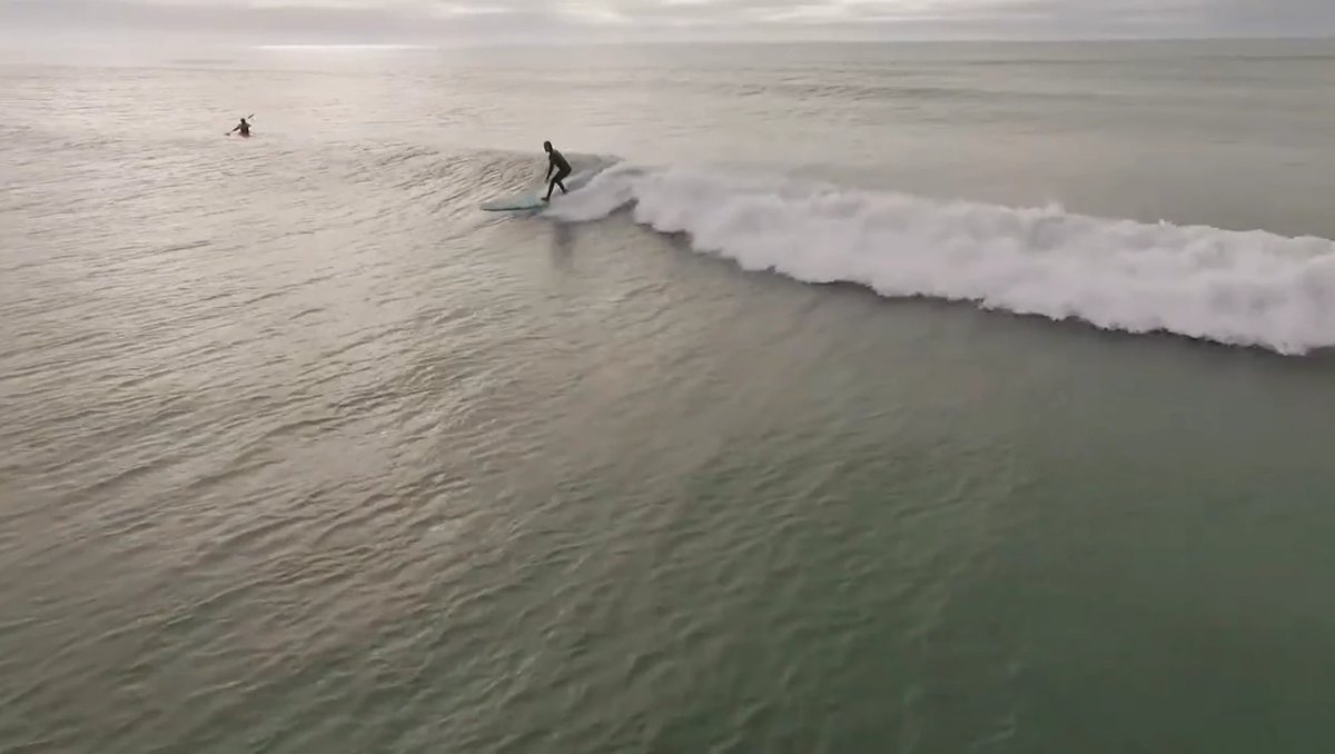 Glassy evening light as a surfer drops in and a kayaker waits beyond, the Scarborough corner at its mellow best, Sumner / Sca