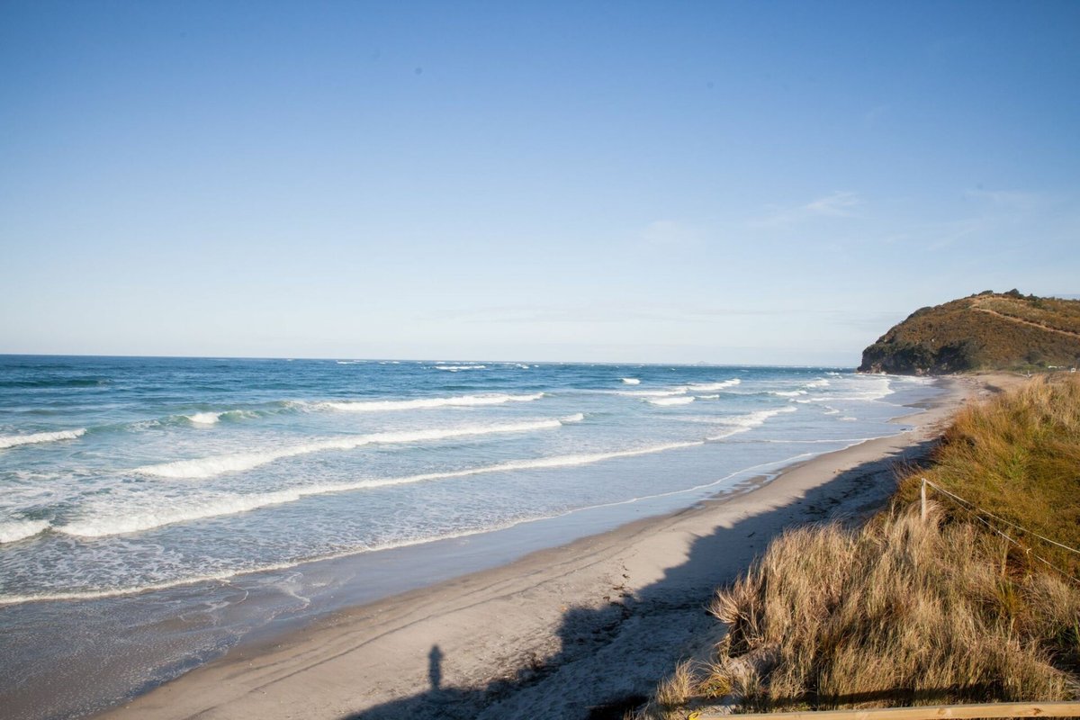 The southern end at Bowentown headland. Lined-up sets on a clean NE morning, Waihi Beach surf spot, Bay of Plenty, New Zealan